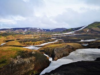 Scenic view of river amidst mountains against sky