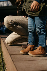 Low section of man tying shoelace