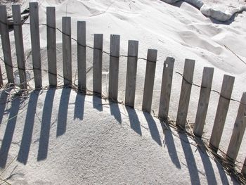 High angle view of picket fence on sand at beach