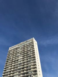 Low angle view of modern building against blue sky