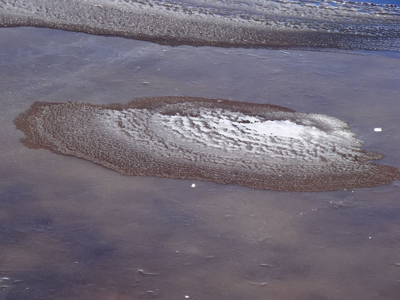 HIGH ANGLE VIEW OF PUDDLE ON WET SHORE