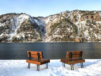 Chairs and table on snowcapped mountain during winter
