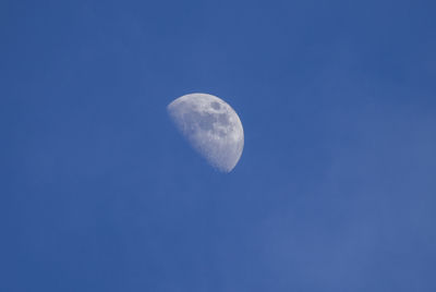 Low angle view of moon against blue sky