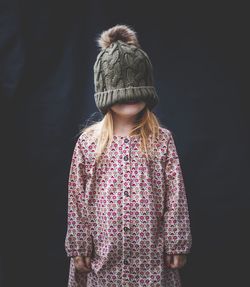 Rear view of girl standing against black background