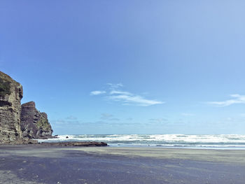 View of calm beach against blue sky