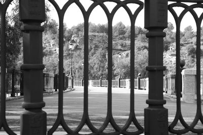 Metallic structure on street seen through fence