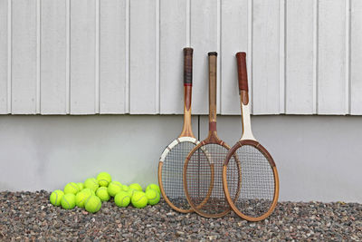 Rackets with tennis balls by wall