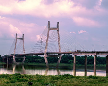 View of suspension bridge against cloudy sky