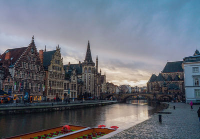 Bridge over river against buildings in city