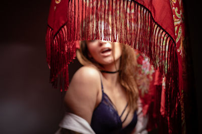 Woman in lingerie standing under covered lighting equipment