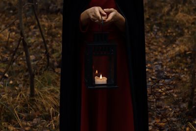 Midsection of woman holding illuminated lighting equipment