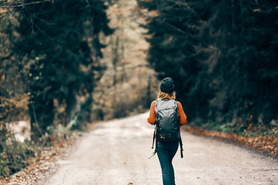 Rear view of woman walking on road