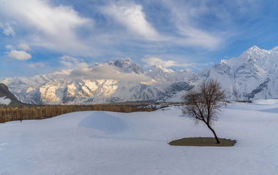 Scenic view of snow covered field against sky