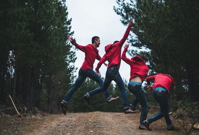 Multiple exposure of young man jumping on dirt road in forest