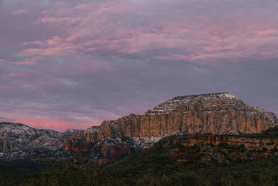 Incredible sunset in sedona arizona in winter with pinks and purples in moody sky. snow on ground.