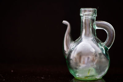 Close-up of glass jar on table against black background