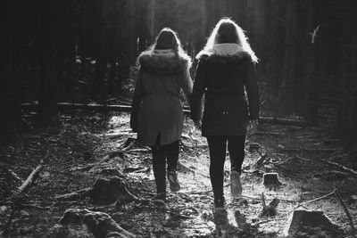 Rear view of women walking in forest