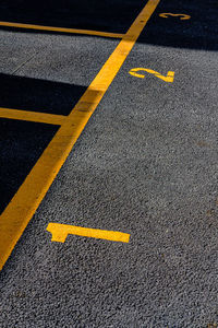 Asphalt parking lot with yellow lot line and yellow lot number 1, 2, 3