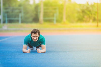 Portrait of young man exercising at stadium