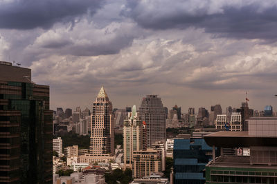 View of cityscape against cloudy sky
