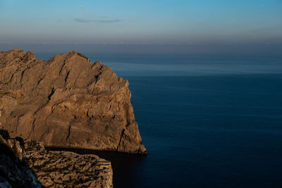 Rock formations by sea against sky