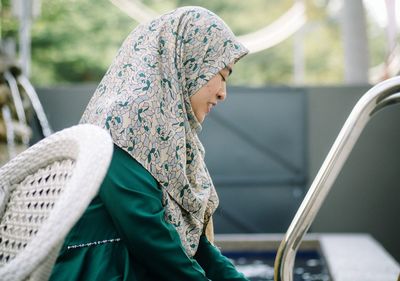 Woman in hijab sitting outdoors