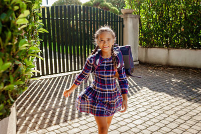 Back to school. girl with backpack goes to school from home at the first day after vacation