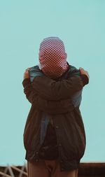 Rear view of woman with umbrella against clear sky