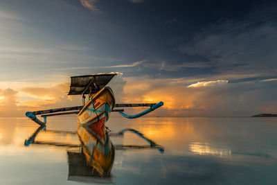 Boat on sea against sky during sunset