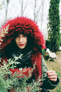 Portrait of woman in fur coat standing by plants in forest