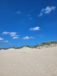 Scenic view of desert against blue sky