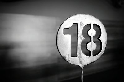 Close-up of sign on wood against wall