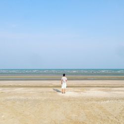 Rear view of man walking on beach