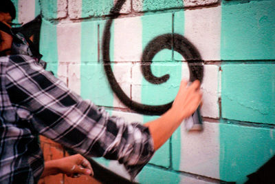 Man holding graffiti on wall