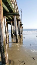 Wooden pier on sea against clear sky