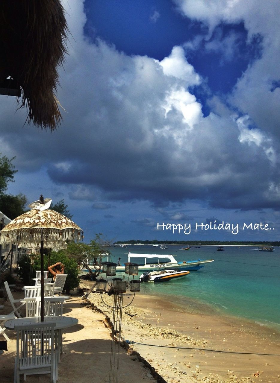 sky, beach, sea, cloud - sky, sand, shore, water, cloudy, built structure, cloud, text, architecture, incidental people, palm tree, outdoors, horizon over water, nature, western script, day, building exterior