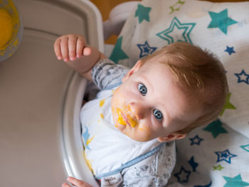 Portrait of cute baby boy eating food at home