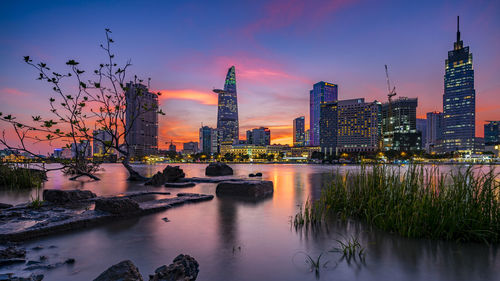 Reflection of buildings in city at sunset