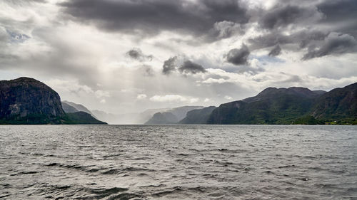 Scenic view of sea and mountains against sky