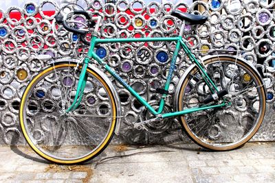 Bicycle leaning on fence at sidewalk