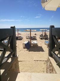 Pier on beach against sky during sunny day
