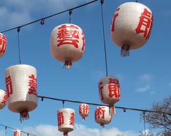 Low angle view of lantern hanging on pole against sky