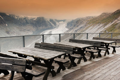 Picnic tables against pasterze glacier during sunset