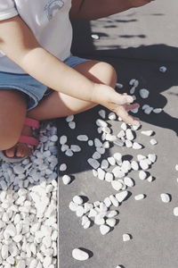 High angle view of woman playing with pebbles