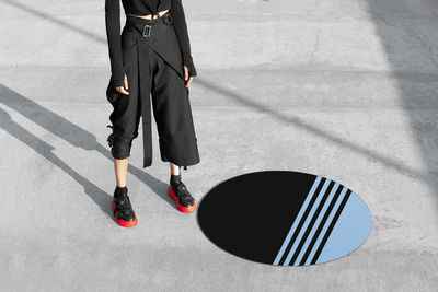 Low section of woman standing on road