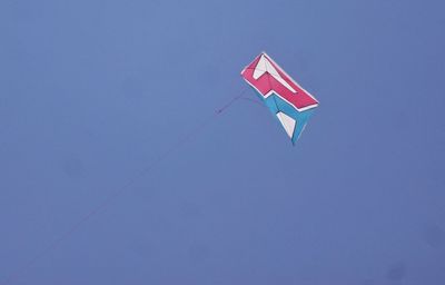 Low angle view of kite against clear blue sky