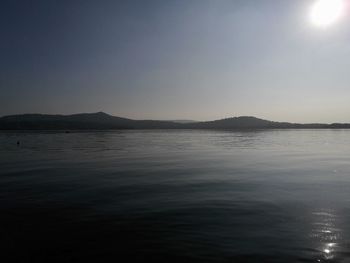 Scenic view of sea and mountains against clear sky