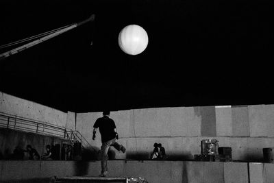 Low angle view of silhouette men against moon at night