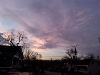 Houses in town against sky at sunset