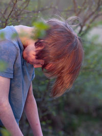 Side view of young woman in plant